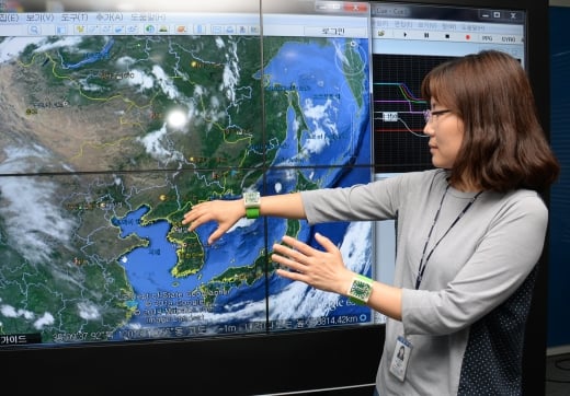ETRI 연구진이 이번에 개발한 웨어러블 제스처 기술을 시연하고 있다. 손목형 밴드에 스마트워치 형태로 만들어 화면을 제어하는 모습/사진=ETRI