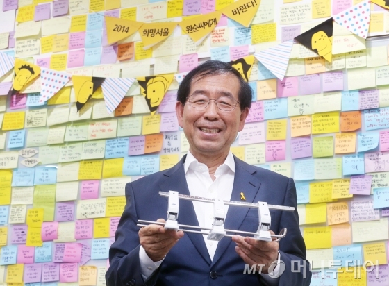 19일 박원순 서울시장이 신청사 집무실에서 그가 평소 아끼는 펀치를 들고 있다. 집무실 벽면을 가득 채운 책장에 빼곡히 박힌 파일은 모두 박 시장은이 직접 모아서 정리한 문서들이다. 박 시장은 "시정 관련 문서들을 내가 정리한다. 그래야 어딨는지 알고 챙길 수 있기 때문"이라고 밝혔다. 책장 옆의 벽면은 시민들이 박 시장에게 바라는 점을 손 글씨로 쓴 포스티잇으로 가득차 있다. 책장 옆으로 박 시장이 서있는 벽면은 시민들이 박 시장에게 바라는 점을 손 글씨로 쓴 포스티잇으로 가득차 있다.