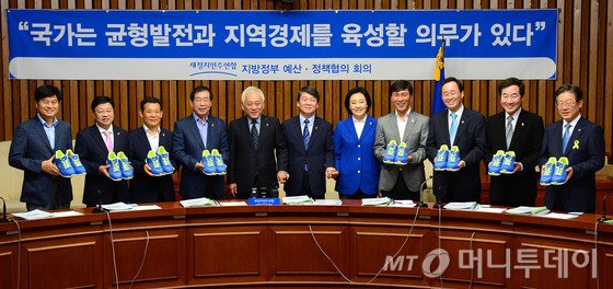 김한길, 안철수 새정치민주연합 공동대표가 22일 오전 여의도 국회에서 열린 민생과 안전, 균형발전을 위한 새정치민주연합 지방 정부 예산, 정책협의회 회의에서 박원순 서울시장을 비롯한 6.4지방선거 광역단체장 당선자들에게 운동화를 전달 후 기념촬영을 하고 있다./사진=뉴스1제공