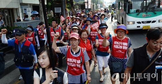 (서울=뉴스1) 허경 기자 최저임금위원회 제6차 전원회의가 열리고 있는 26일 오후 서울 종로구 보신각 앞에서 열린 민주노총 "최저임금 현실화·생활임금 성취 결의대회"를 마친 참가자들이 거리행진을 하고 있다. 2014.6.26/뉴스1