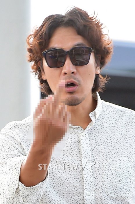 배우 김민준이 스케줄을 소화하기 위해 28일 오전 인천국제공항을 통해 출국장에 들어서던 중 카메라를 향해 손가락 욕을 하고 있다./사진=스타뉴스