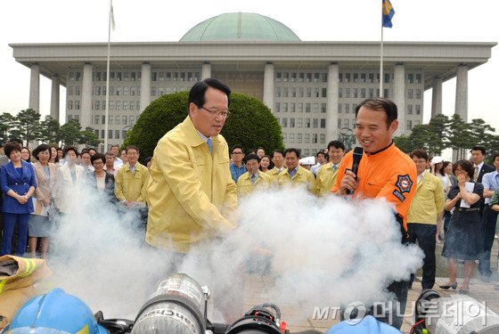 (서울=뉴스1) 박철중 기자 제394차 민방위의 날인 20일 오후 서울 여의도 국회 중앙분수대 앞에서 정의화 의장이 소화기 사용법을 체험하고 있다. 2014.6.20/뉴스1