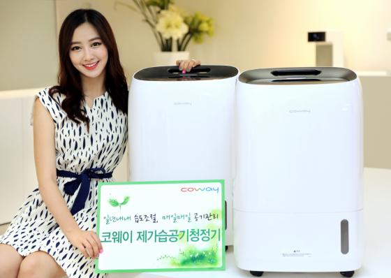 코웨이 모델이 제습과 가습, 공기청정기능을 모두 갖춘 제·가습 공기청정기 'APT-1014E'를 소개하고 있다./사진제공=코웨이