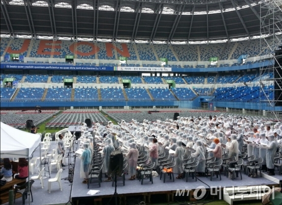 15일 교황이 대전월드컵경기장에서 집전하는 성모승천대축일 미사를 하루 앞둔 14일 성가대원들이 간간히 내리는 비에도 불구하고 우의를 입은 채 성가연습을 하고 있다.