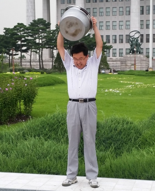 김용태 새누리당 의원이 20일 서울 여의도 국회에서 루게릭병(ALS) 알리기 자선모금 캠페인 '아이스 버킷 챌린지'에 참여해 양동이에 담긴 얼음물을 몸에 끼얹고 있다/ 사진=뉴스1