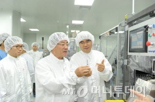 지난 25일 이인석 SK케미칼 사장(맨 오른쪽)이 정승 식약처장(가운데)에게 세포배양방식 독감백신 제조공정에 대해 설명하고 있다./사진제공=식품의약품안전처