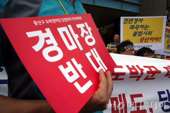 7월6일 오전 한국마시회와 지역주민들 간 갈등의 원인이 된 용산 화상경마장(마권 장외발매소) 앞에서 화상경마장의 개장을 반대하는 지역주민(왼쪽)들과 찬성하는 이들이 손피켓과 플래카드를 들고 시위를 벌이고 있다. /사진=뉴스1