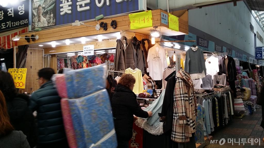 ‘꽃분이네’와 벽을 맞대고 있는 ‘체리’. 다음달 20일 가게 폐업을 앞두고 '원가세일'을 하고 있다. 옷을 정리하고 있는 이가 체리 사장 성정숙씨. /사진=양영권 기자