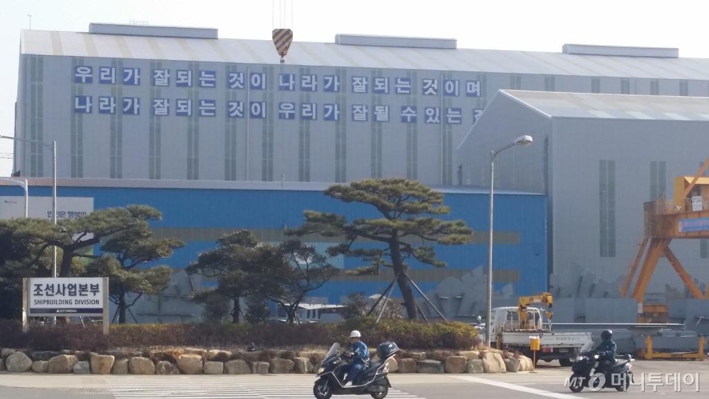 울산 동구 현대중공업 조선소에 근로자들이 오토바이를 타고 이동하고 있다. 조선소 건물에는 '우리가 잘 되는 것이 나라가 잘 되는 것이며, 나라가 잘 되는 것이 우리가 잘 될 수 있는 길이다'라는 정주영 창업주의 어록이 새겨져 있다. /사진=양영권 기자