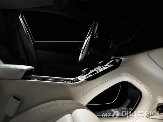 올-뉴 200은 센터 콘솔의 패스스루 수납공간 바닥은 디트로이트 스카이라인을 새겨 넣은 고무로 마무리 했다. 아이패드 등 제법 큰 휴대기기를 놓고 중앙에 뚫린 구멍으로 선을 뽑아 깔끔하게 이용할 수 있다./사진제공=FCA