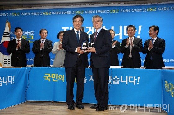 새정치민주연합 문재인 대표가 25일 인천시 신동근 후보사무실에서 열린 현장최고위원회의에서 신 후보에게 선전을 다짐하는 의미로 운동화를 전달하고 있다./사진=뉴스1
