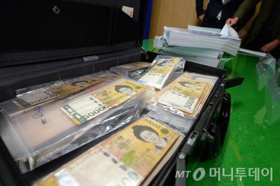 한전케이디엔(KDN) 직원 490여 명이 10만원씩 후원금 쪼개기 방식으로 국회의원 4명에게 입법 로비를 시도한 것으로 밝혀졌다. 2014년 11월 경찰이 공개한 현금 뭉치가 든 서류가방 등 관련 압수품./사진=뉴스1