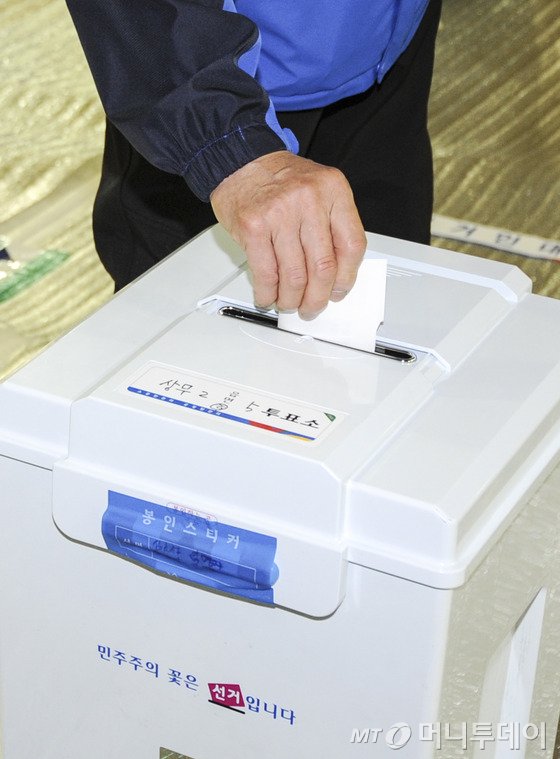 4·29 국회의원 재·보궐선거일인 29일 오전 광주 서구 치평중학교 체육관에 마련된 투표소에서 유권자들이 투표용지를 투표함에 넣고 있다. 2015.4.29/뉴스1  <저작권자 ⓒ 뉴스1코리아, 무단전재 및 재배포 금지>