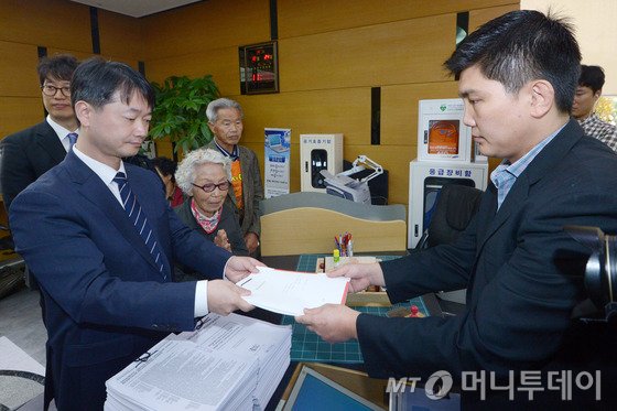 전국 송전탑반대 네트워크 회원들과 밀양 주민 어르신들이 지난해 10월 서울 종로구 북촌로 헌법재판소 민원실에서 송주법 및 전기사업법 관련 헌법 소원 청구서를 담당자에게 제출하고 있다. / 사진 = 뉴스1