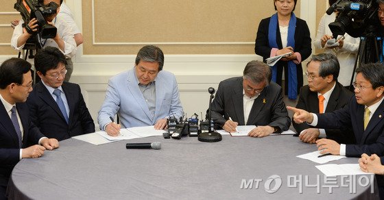 김무성 새누리당 대표와 문재인 새정치민주연합 대표가 2일 오후 서울 여의도 국회에서 공무원연금 개혁 합의문에 서명하고 있다. 여야는 오는 6일 본회의에서 공무원연금법 개정안을 처리키로 최종 합의했다. 2015.5.2/뉴스1 <저작권자 © 뉴스1코리아, 무단전재 및 재배포 금지>