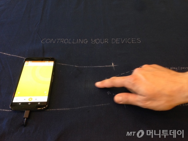 구글 I/O 전시장에 마련된 '프로젝트 잭쿼드(Jacquard)'. 천 위에 있는 특정부위에 손가락을 갖다 대고 움직이면 스마트폰 위에 터치한 것과 같은 효과를 낸다.