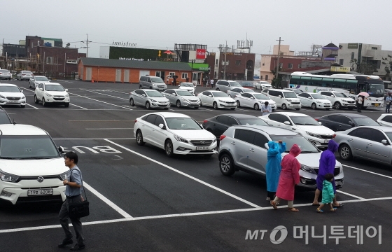 6월27일 성산일출봉 입구 버스 주차장에 승용차들이 주차해놨다. 관광버스는 단 한대만 눈에 띈다. /사진=김유경기자