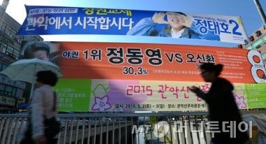 4.29 재보궐선거를 이틀 앞둔지난 4월 27일 오후 서울 신림역 부근에 설치된 선거 현수막 앞으로 시민들이 발걸음을 재촉하고 있다. / 사진=뉴스1