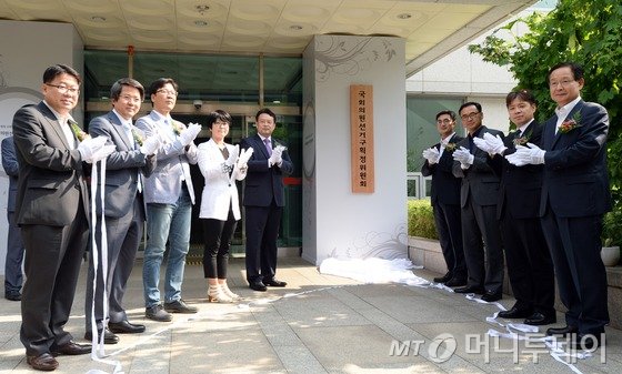 15일 오후 서울 관악구 남현동 중앙선거관리위원회 관악청사에 마련된 국회의원 선거구획정위원회 사무국에서 김대년 위원장과 위원들이 현판 제막을 마친 뒤 함께 기념촬영하고 있다.이날 출범한 선거구획정위는 공청회 등 의견 수렴을 거쳐 내년 총선 6개월 전인 오는 10월13일까지 선거구 획정안을 국회에 제출할 계획이다.왼쪽부터 강경태 신라대 교수, 김동욱 서울대 교수, 조성대 한신대 교수, 김금옥 한국여성단체연합 상임대표, 김대년 위원장, 이준한 인천대 교수, 차정인 부산대 교수, 가상준 단국대 교수, 한표환 충남대 교수. 2015.7.15/뉴스1  <저작권자 © 뉴스1코리아, 무단전재 및 재배포 금지>