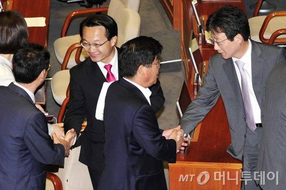 새누리당 유승민 원내대표(오른쪽), 조해진 원내수석부대표가 지난 5월 29일 새벽 서울 여의도 국회에서 열린 5월 임시국회 마지막 본회의에서 공무원연금법 개정안 등 60여 개 법안이 처리된 뒤 동료 의원들과 악수를 나누고 있다.