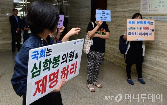 4일 서울 여의도 국회에서 열린 심학봉 무소속 의원의 성폭행 혐의 징계안과 관련 윤리특별위원회 전체회의장 앞에서 여성단체 회원들이 심 의원의 제명을 촉구하는 내용이 적힌 피켓을 들고 있다. 앞서 심 의원은 경찰로부터 40대 여성 보험설계사를 성폭행한 혐의를 받다 새누리당을 탈당한 바 있다. 이와 관련해 국회 윤리심사자문위원회는 심 의원 징계의 건을 논의했고 만장일치로 '의원직 제명' 의견을 제시하기로 결정했다. 2015.9.4/뉴스1  <저작권자 © 뉴스1코리아, 무단전재 및 재배포 금지>