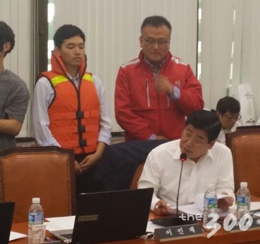 이이재 새누리당 의원이 11일 국회에서 열린 해양수산부 국정감사에서 저렴한 비치용 구명조끼(왼쪽) 최신형 구명조끼의 차이점을 설명하고 있다/ 사진=정혜윤 기자