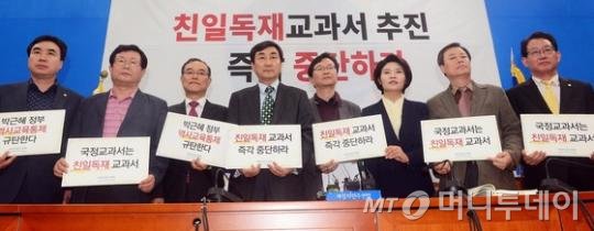 새정치민주연합 이종걸 원내대표가 11일 서울 여의도 국회에서 열린 국정교과서 저지를 위한 긴급대책회의에서 참석자들과 함께 '친일독재 교과서 즉각 중단하라'고 적힌 피켓을 들고 있다. 2015.10.11/뉴스1
