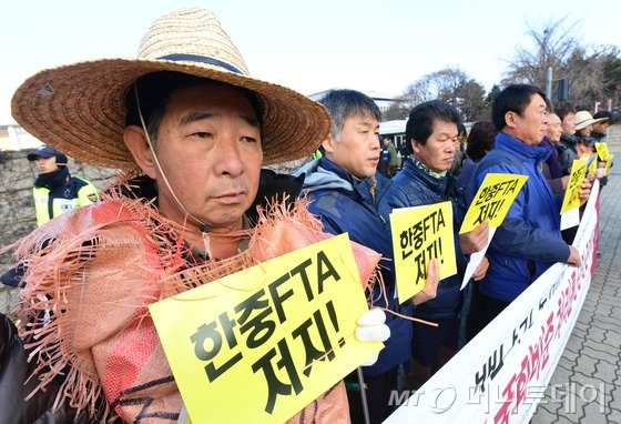 농민의길, 환경농업단체연합회 등 농민단체들이 30일 오전 서울 여의도 국회의사당 앞에서 기자회견을 열고 한중FTA 국회비준 처리 중단을 촉구하고 있다. 2015.11.30/뉴스1