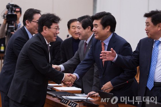 윤상직 산업통상자원부 장관이 30일 서울 여의도 국회에서 열린 외교통일위원회 전체회의에서 한·중 FTA 비준동의안 등이 의결된 후 원유철 새누리당 원내대표를 비롯한 여당의원들과 인사를 나누고 있다. 2015.11.30/뉴스1 <저작권자 © 뉴스1코리아, 무단전재 및 재배포 금지>