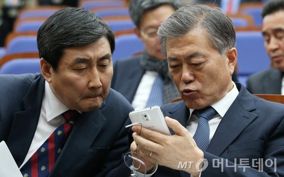 새정치민주연합 문재인 대표와 이종걸 원내대표가 2일 국회에서 열린 의원총회에서 정의화 국회의장이 여야 원내지도부가 합의한 5개 쟁점법안을 '직권상정'하기로 잠정 결론내렸다는 뉴스 속보를 보며 대화를 나누고 있다. 2015.12.2/뉴스1