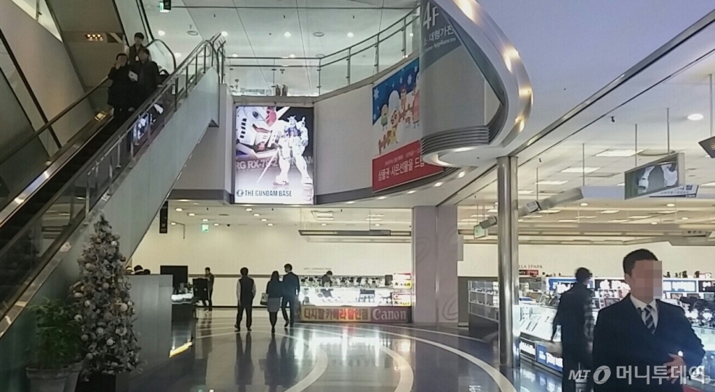 용산 아이파크몰 내 전자상가들. 뒷편 면세점 부지를 흰 벽이 가로막고 있다.