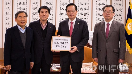 새누리당 장윤석 의원을 비롯한 농어촌 지역구 의원들이 31일 서울 여의도 국회 의장실을 찾아 정의화 국회의장에게 선거구 획정 관련 건의문을 전달하고 있다. 이들은 선거구 획정과 관련해 "공직선거법에 명시된 선거구의 시군구 분할금지 규정을 개정해야 한다"며 "정의화 국회의장이 합헌적으로 선거구 획정이 이뤄질 수 있도록 조치해달라"고 호소했다. 왼쪽부터 무소속 황주홍, 새누리당 장윤석 의원, 정의화 국회의장, 신성범 의원. 2015.12.31/뉴스1