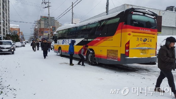 눈에 파묻힌 제주. 24일 오후 제주시 노형동일대에서 한 관광버스 기사가 체인을 감아걸고있다./사진=조성훈기자