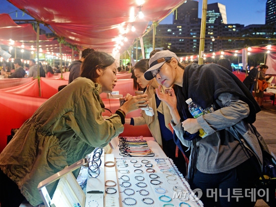 1일 오후 서울 영등포구 여의도 한강공원에서 열린 '서울 밤도깨비 야시장'을 찾은 시민들이 쇼핑을 하고 있다.여의도 한강공원에서 올해 처음 열리는 '서울 밤도깨비 야시장'은 전국에서 모인 푸드트럭들이 선보이는 다양한 먹거리가 일품이다. 이외에도 생활소품, 아이디어상품, 빈티지 제품 등을 판매하는 신개념 야시장이다. 2015.10.1/뉴스1 <저작권자 © 뉴스1코리아, 무단전재 및 재배포 금지>