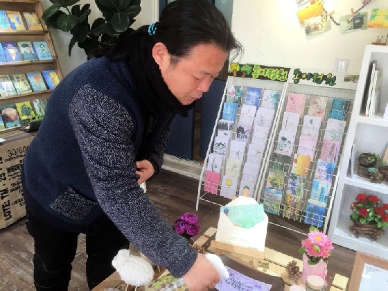 김명진(45) 협동조합'온리'이사장이 싹이 돋아난 씨앗수제카드에 물을 주고 있다.