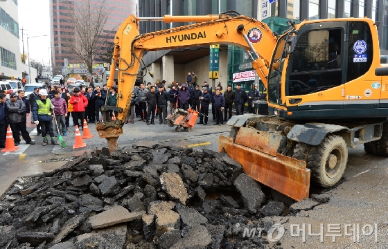 25일 오후 서울 중구 시청역 9번 출구 앞 서소문로 도로에 지반침하 현상이 일어나 굴삭기로 도로 아스팔트 포장을 걷어내고 지반 침하 원인을 조사하고 있다. 이날 오후 1시쯤 지하철 시청역 9번출구 앞 도로가 가로3m, 세로6m 규모로 내려 앉았다. 2016.2.25/뉴스1<br>