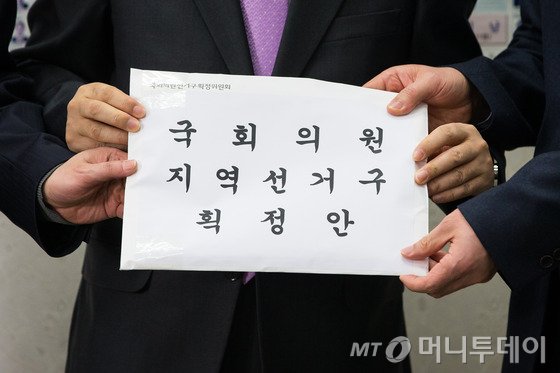 김세환 국회의원선거구획정위원회 사무국장이 28일 서울 여의도 국회에서 이명우 국회 정무수석비서관에게 선거구획정안을 전달하고 있다. 2016.2.28/뉴스1