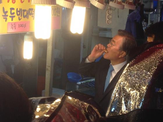 더불어민주당의 문재인 전 대표가 서울 동작구 남성시장에서 진행된 허동준 후보 지원유세에서 전을 시식하고 있다. 사진=최경민 기자