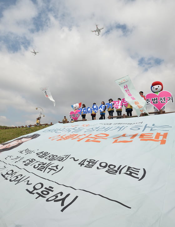 제20대 국회의원선거 사전투표를 하루 앞둔 7일 오전 경기도 수원시 장안구 광교산 입구에서 경기도선거관리위원회 직원들이 드론을 이용해 투표참여를 촉구하는 캠페인을 펼치고 있다/사진=뉴스1