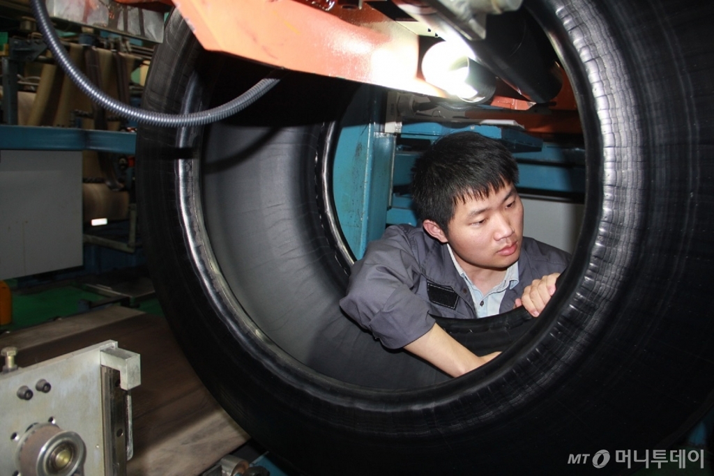 한국타이어 충칭공장에서 완성품 중간 단계의 '그린타이어'의 품질에 이상이 없는지 근로자들이 살펴보고 있다. /사진제공=한국타이어