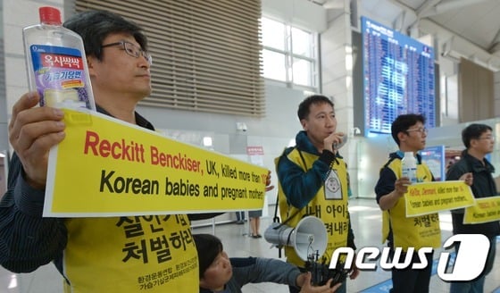 7박8일의 일정으로 옥시레킷벤키저 영국 본사 항의 방문에 나선 환경보건시민센터 최예용 소장(왼쪽부터)과 가습기 살균제 사망사건 피해 유족 김덕종, 안성우 씨가 4일 인천국제공항 출국장에서 옥시를 규탄하는 피켓을 들고 있다./사진=뉴스1