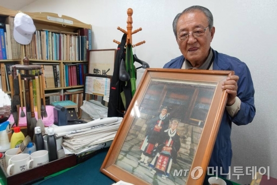 이기전 인간문화재가 20여 년 전 종묘대제를 거행하며 찍은 사진이 담긴 액자를 보여주고 있다. /사진=김유진 기자