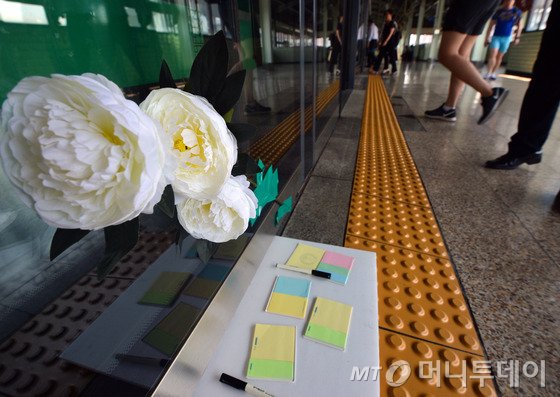 30일 오전 서울 광진구 구의역 9-4번 승강장에서 사고를 당한 김모(19)씨를 추모하는 국화와 포스트잇이 붙어 있다. 김 씨는 지난 28일 오후 지하철 2호선 구의역의 고장난 안전문(스크린도어)을 고치다 승강장에 들어오는 열차와 스크린도어 사이에 끼여 숨졌다. 2016.5.30/뉴스1 <저작권자 © 뉴스1코리아, 무단전재 및 재배포 금지>