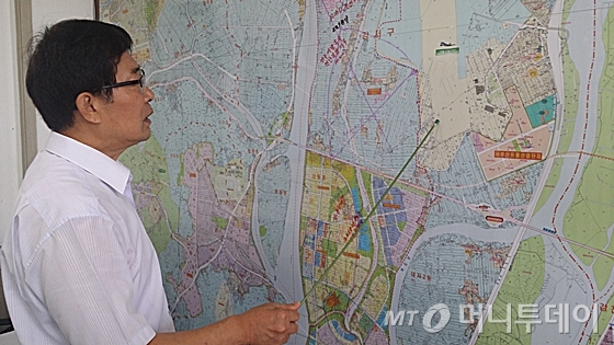 부산시 강서구 강동동 Y공인중개업소 관계자가 김해공항 활주로 추가건설로 인한 소음피해 우려 지역을 설명하고 있다 ./사진=신현우 기자