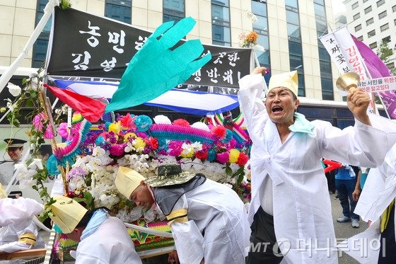화훼협회 회원들이 29일 오후 서울 영등포구 국회의사당 앞에서 열린 '부정 청탁 및 금품 수수 금지법(김영란법) 시행령 반대 집회'를 마친 뒤 상여를 메고 새누리당사 앞을 행진하던 중 상여를 부수며 청탁금지법 개정을 요구하고 있다.2016.6.29/뉴스1