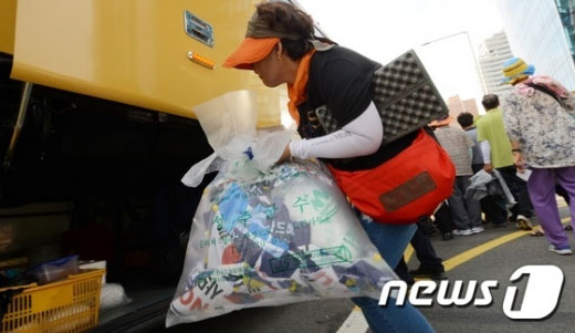 21일 오후 서울역 광장에서 열린 '사드(THAAD·고고도미사일방어체계) 배치 반대 집회'를 마친 성주 주민이 버스에 쓰레기봉투를 싣고 있다. /사진제공=뉴스1