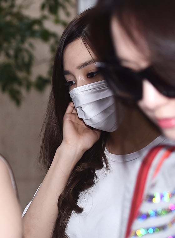 소녀시대 티파니가 15일 오후 'SMTOWN LIVE'(에스엠타운 라이브) 콘서트를 마치고 김포국제공항을 통해 입국해 멤버들에게 둘러싸여 마스크를 한 채 입국장을 나서고 있다./사진= 뉴스1