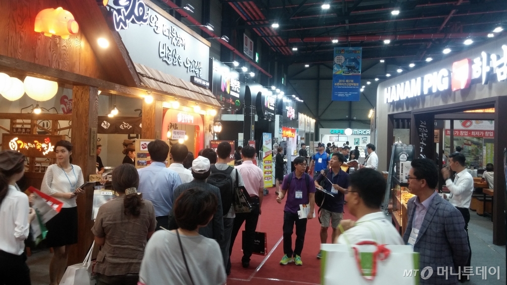 25일 서울 강남구 학여울역 세텍에서 열린 프랜차이즈산업박람회를 찾은 관람객들이 부스를 둘러보고 있다 / 사진=민동훈 기자