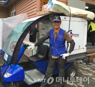 5년차 실버택배원 이은호(77) 어르신이 배달준비를 마치고 카메라를 향해 활짝 웃고 있다. /사진=김도영 기자