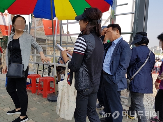 서울 마포구 신수동 '신촌숲 아이파크' 모델하우스 한켠에서 한 중년 여성이 방문객을 대상으로 전화번호 등을 수집하고 있다. /사진=신현우 기자